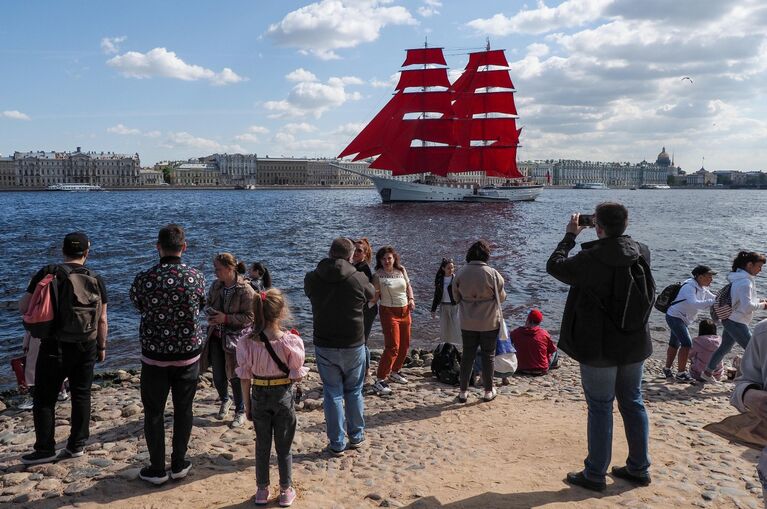 Отдыхающие фотографируют бриг Россия, прибывший к празднику Алые паруса, в акватории Финского залива в Санкт-Петербурге