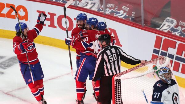 Хоккеисты Монреаль Канадиенс празднуют заброшенную шайбу в матче с Виннипег Джетс.
