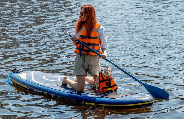 Девушка на sup-борде со своим питомцем на фестивале Petshop Days 2021 в Приморском парке Победы на Крестовском острове в Санкт-Петербурге