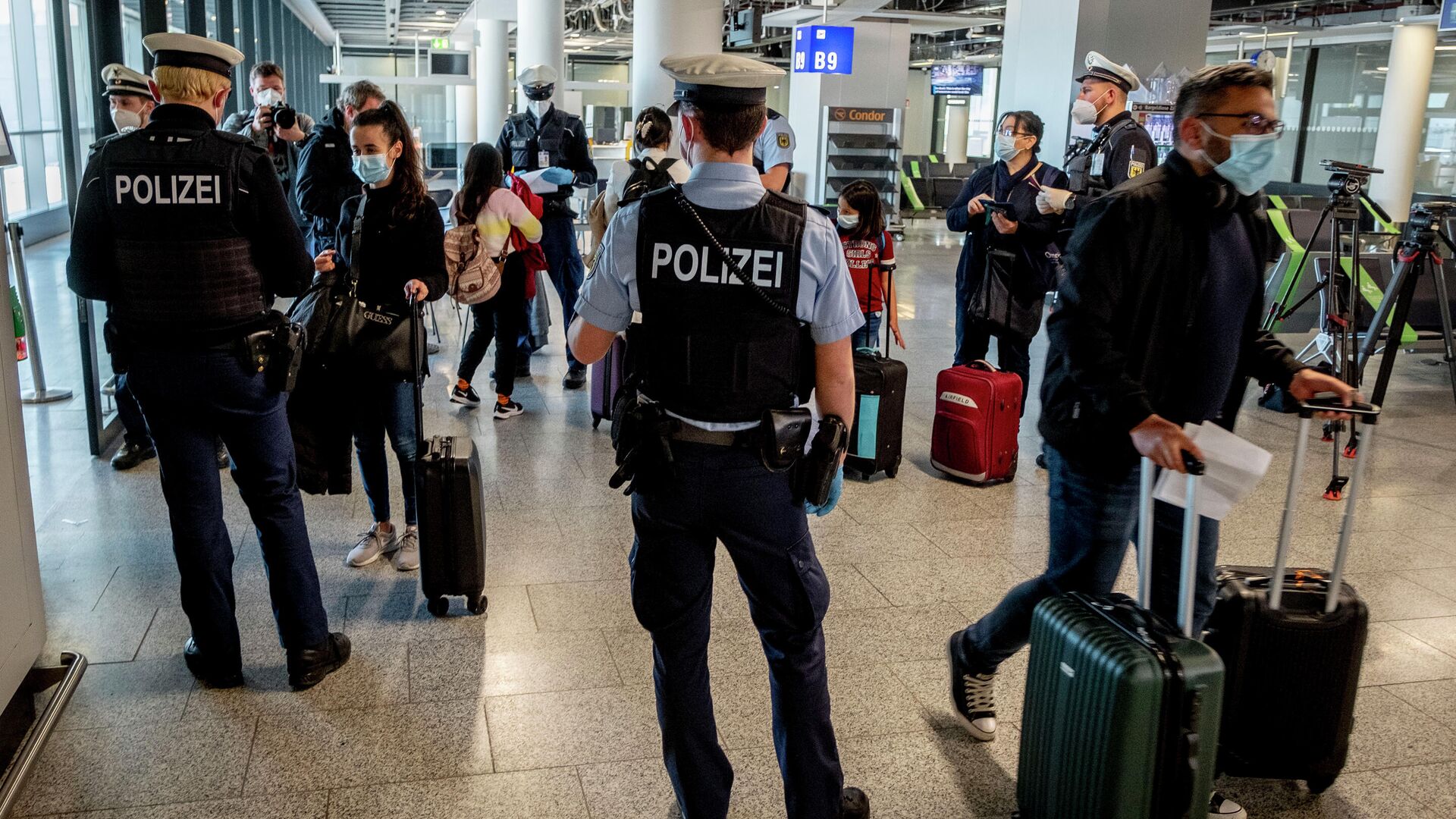 Сотрудники полиции проверяют наличие теста на коронавирус у прибывших пассажиров в аэропорту Франкфурта, Германия - РИА Новости, 1920, 02.12.2021