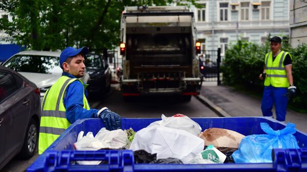Сотрудники коммунальных служб во время уборки мусора на Малой Бронной улице в Москве.
