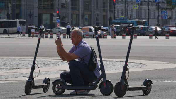 Мужчина с электросамокатами на Дворцовой площади в Санкт-Петербурге