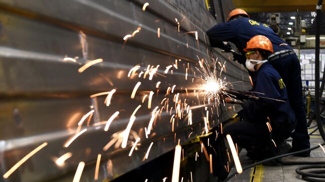 Рабочие на линии сборки вагонов на Тверском вагоностроительном заводе