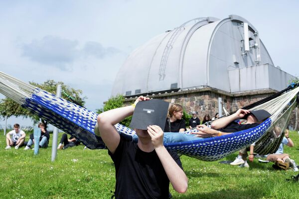 Люди смотрят частичное солнечное затмение в обсерватории Brorfelde в Дании