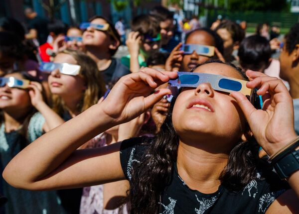 Дети наблюдают частичное солнечное затмение в Схидаме, Нидерланды. 10 июня 2021 года