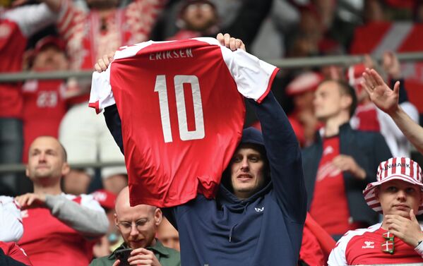 Болельщик сборной Дании держит футболку с номером Кристиана Эриксена