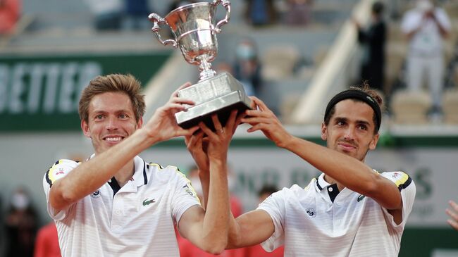 Tennis - French Open - Roland Garros, Paris, France - June 12, 2021 France's Pierre-Hugues Herbert and Nicolas Mahut celebrate with the trophy after winning their men's doubles final match against Kazakhstan's Alexander Bublik and Andrey Golubev REUTERS/Benoit Tessier