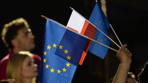 Люди с флагами Евросоюза и Польши