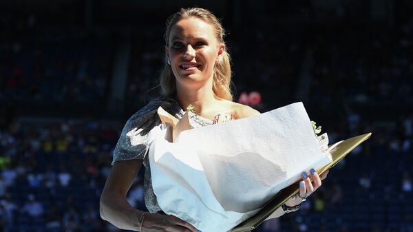 Denmark's Caroline Wozniacki holds a bouquet of flowers after a special ceremony following the women's singles semi-final match between Australia's Ashleigh Barty and Sofia Kenin of the US on day eleven of the Australian Open tennis tournament in Melbourne on January 30, 2020. (Photo by Manan VATSYAYANA / AFP) / IMAGE RESTRICTED TO EDITORIAL USE - STRICTLY NO COMMERCIAL USE