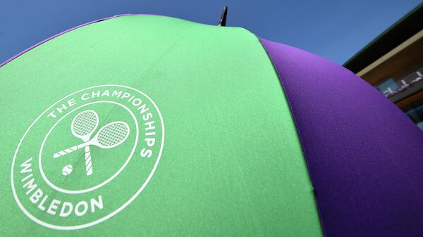An unmbrella with the Wimbledon Championships tennis tournament's logo is seen at The All England Tennis Club in Wimbledon, southwest London, on July 4, 2019, on the fourth day of the 2019 Wimbledon Championships tennis tournament. (Photo by Glyn KIRK / AFP) / RESTRICTED TO EDITORIAL USE