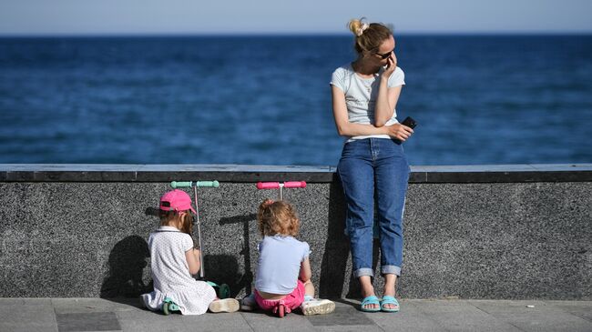 Девушка с детьми на набережной. Архивное фото