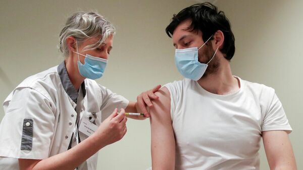 Медицинский работник делает прививку от COVID-19 во время испытаний вакцины CureVac