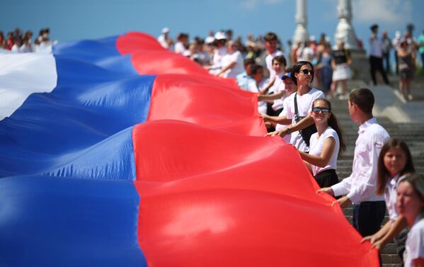 Жители Волгограда несут стометровый флаг России по центру города