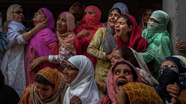Родственники и соседи плачут во время похорон полицейского, убитого в перестрелке на окраине Сринагара, Индия