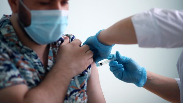 Мужчина во время вакцинации против короновирусной инфекции препаратом КовиВак