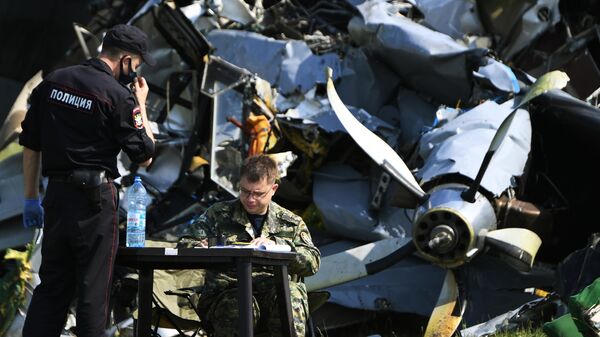 Сотрудники Следственного комитета России и правоохранительных органов работают на месте крушения самолета Л-410 в Кемеровской области