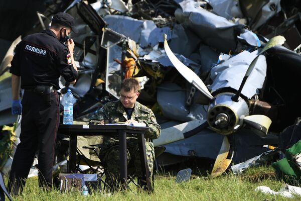 Сотрудники Следственного комитета России и правоохранительных органов работают на месте крушения самолета Л-410 в Кемеровской области