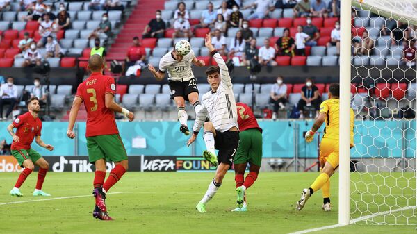 Полузащитник сборной Германии Робин Госенс забивает мяч в ворота португальцев
