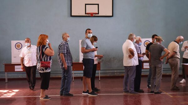 Люди в одном из избирательных участков во время досрочных парламентских выборов в Армении