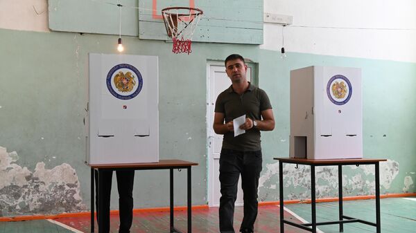 Мужчина голосует на одном из избирательных участков в Ереване во время досрочных парламентских выборов в Армении