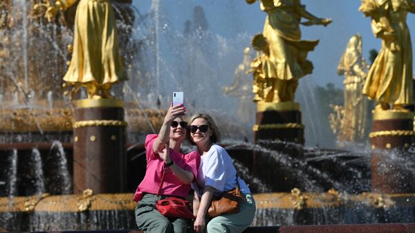 Девушки отдыхают в жаркую погоду у фонтана Дружба народов на ВДНХ