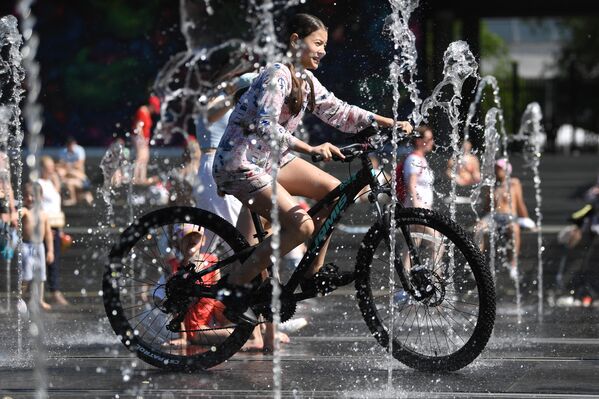 Девушка на велосипеде в Парке искусств Музеон в Москве в жаркую погоду