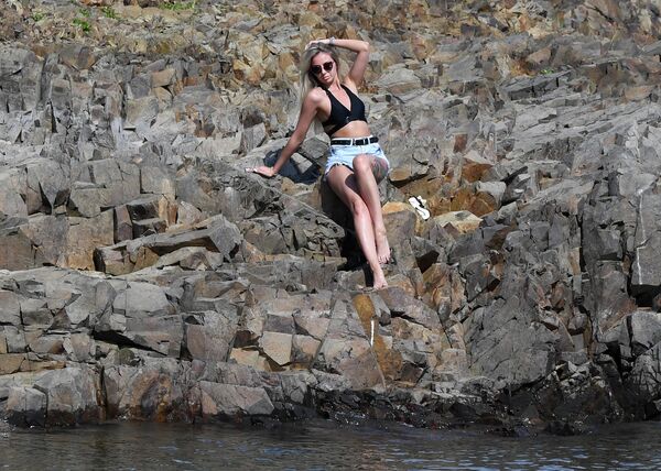 Девушка отдыхает на берегу Енисея в жаркий день в окрестностях посёлка Хмельники Красноярского края