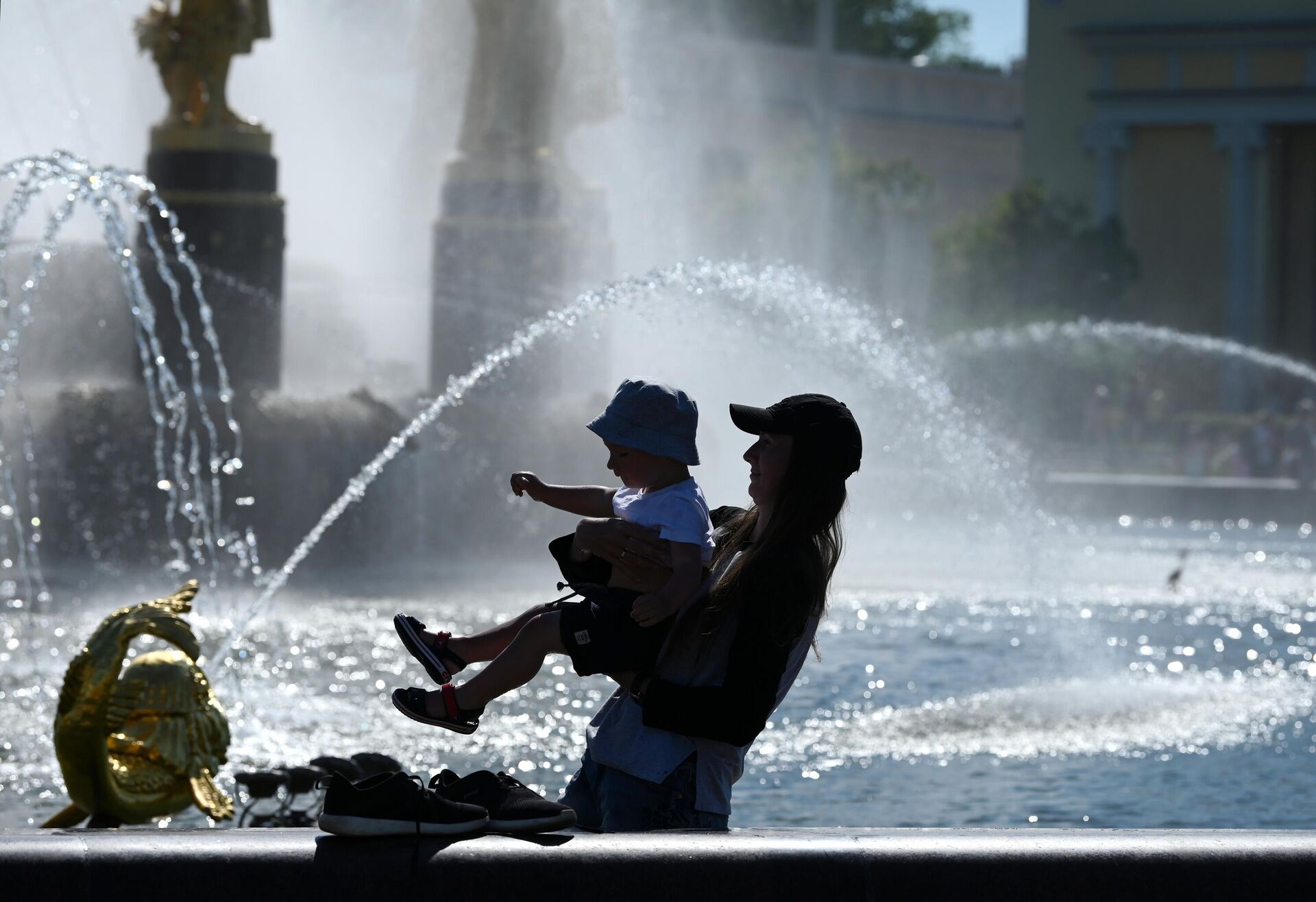 Женщина с ребенком в жаркую погоду у фонтана Дружба народов на ВДНХ - РИА Новости, 1920, 05.05.2022