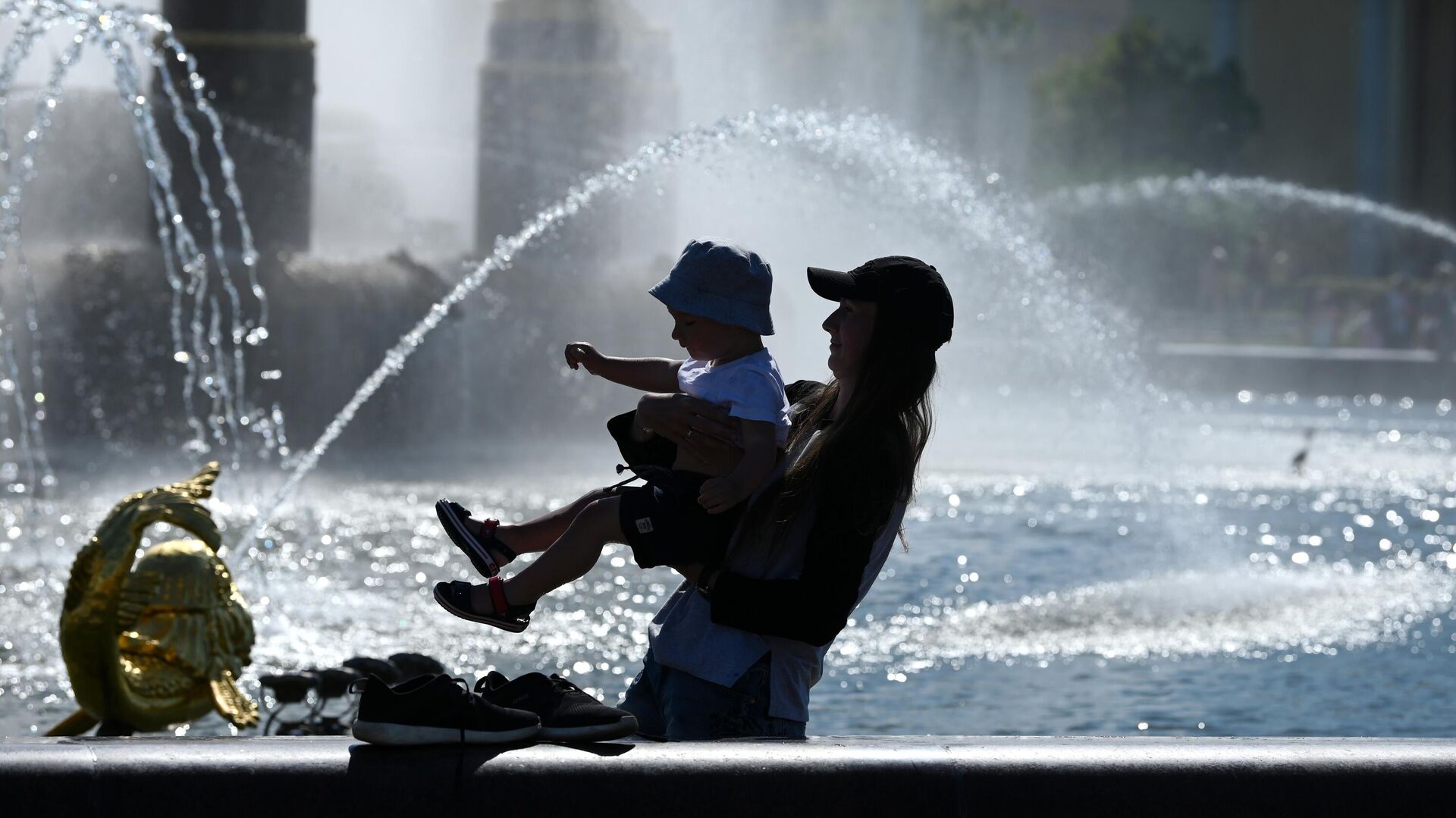 Женщина с ребенком в жаркую погоду у фонтана Дружба народов на ВДНХ - РИА Новости, 1920, 25.06.2021