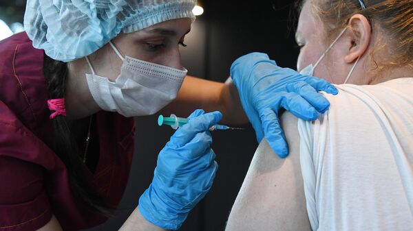 Девушка вакцинируется от COVID-19 препаратом Sputnik V (Гам-КОВИД-Вак) в организации Gastro инкубатор в Новосибирске