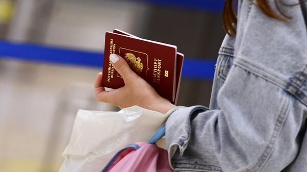 Девушка держит российский загранпаспорт
