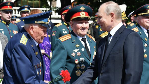 Президент РФ Владимир Путин приветствует ветеранов на церемонии возложения цветов к Могиле Неизвестного Солдата в Александровском саду в День памяти и скорби
