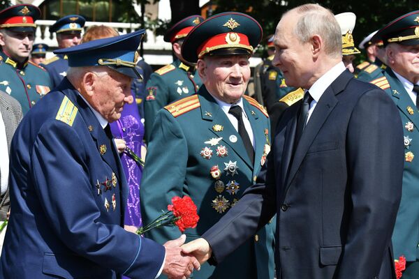 Президент РФ Владимир Путин приветствует ветеранов на церемонии возложения цветов к Могиле Неизвестного Солдата в Александровском саду в День памяти и скорби