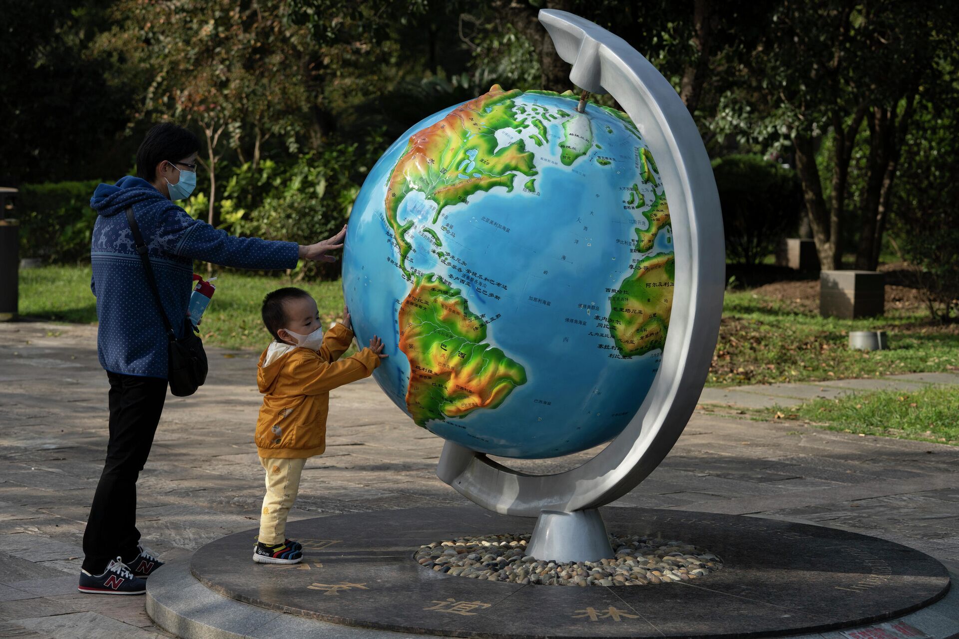 Женщина с ребенком у глобуса в парке в Ухани, Китай - РИА Новости, 1920, 09.03.2022