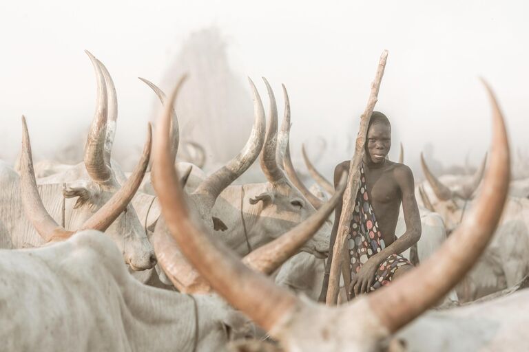 Работа фотографа из Швейцарии Josef Burgi The Mundari Cattle Herder, занявшая первое место в категории Экологический портрет в конкурсе The International Portrait Photographer of the Year 2021 