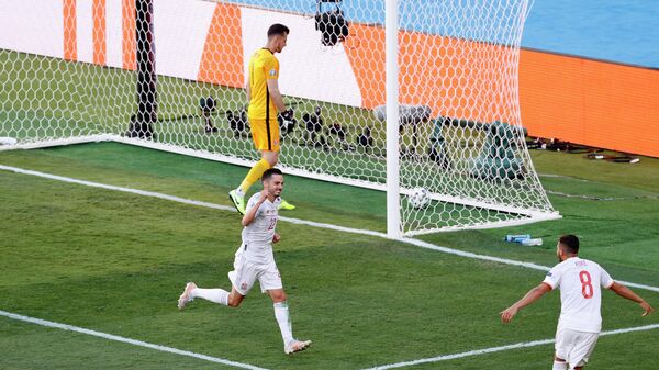 Игроки сборной Испании празднуют забитый мяч в ворота команды Словакии.
