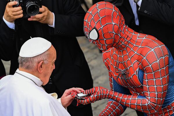 Мужчина в костюме Человека-паука вручает маску Человека-паука Папе Франциску в Ватикане