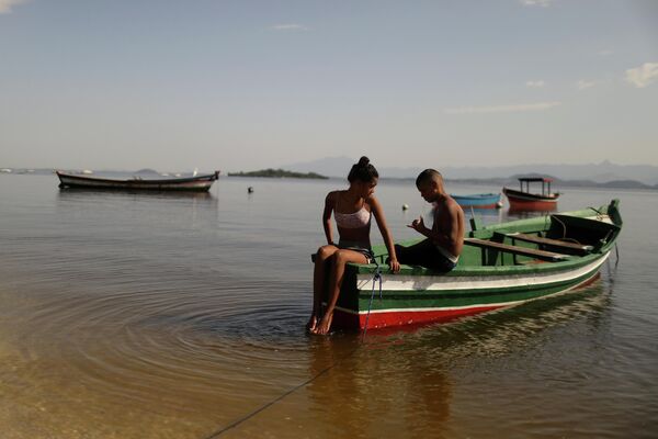 Молодежь отдыхает на лодке на острове Пакета во время массовой вакцинации против COVID-19, Рио-де-Жанейро, Бразилия.