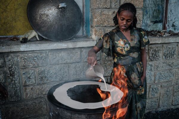 Женщина готовит инджеру, основной продукт Эфиопии - кисло-ферментированные лепешки. Тигрей, Эфиопия