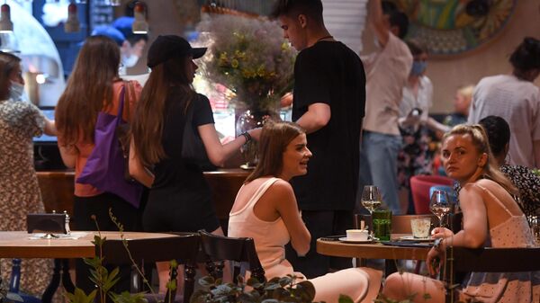 Девушки за столиками в летнем кафе в Москве