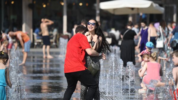 Молодые люди в жаркую погоду гуляют в фонтанах в ЦПКиО имени Горького в Москве