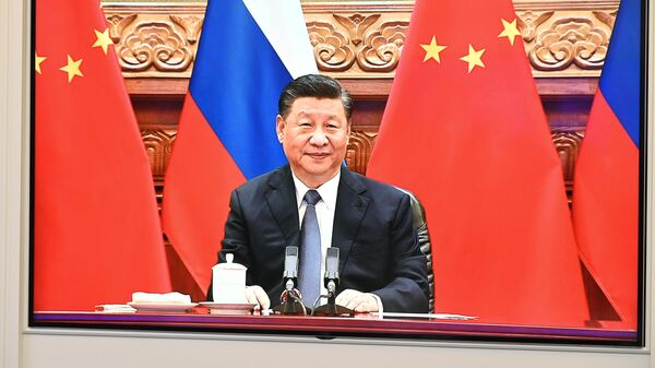 Председатель КНР Си Цзиньпин во время беседы в формате видеоконференции с президентом РФ Владимиром Путиным