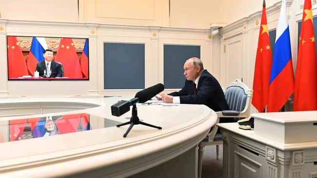 Президент РФ Владимир Путин и председатель КНР Си Цзиньпин во время беседы в формате видеоконференции