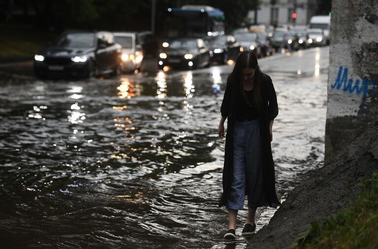 Девушка идет по одной из улиц в Москве во время дождя Девушка идет по одной из улиц в Москве во время дождя