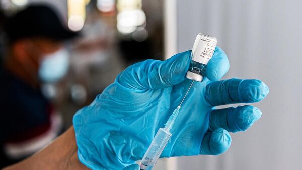 Медицинский сотрудник наполняет шприц однокомпонентной вакциной Спутник Лайт против короновирусной инфекции