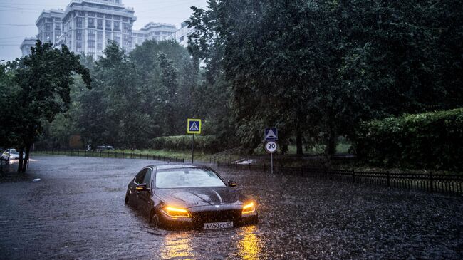 Автомобили на одной из улиц в Москве во время дождя