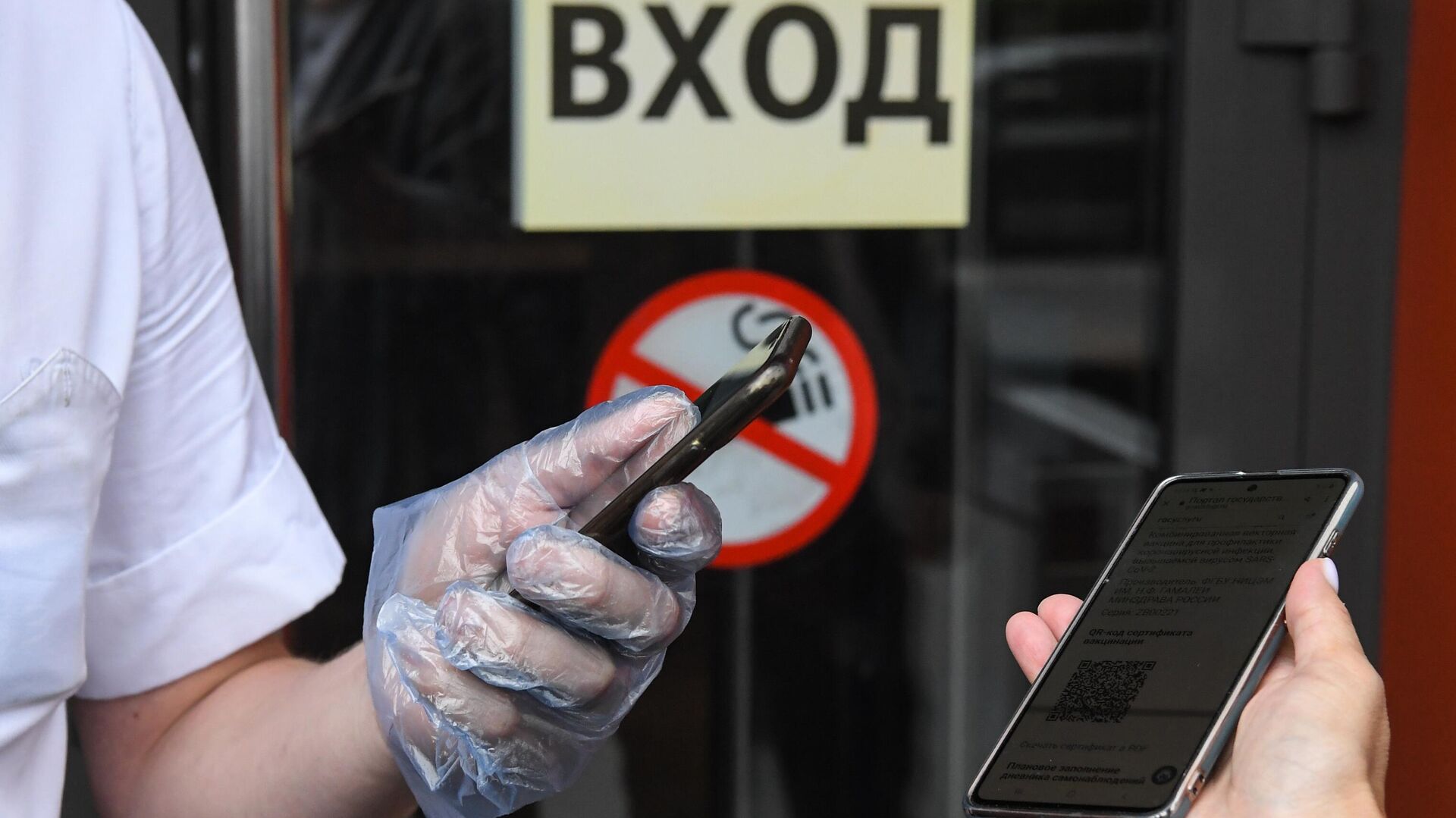 Сотрудник сканирует QR-код у входа в ресторан McDonald's в Москве - РИА Новости, 1920, 24.08.2021