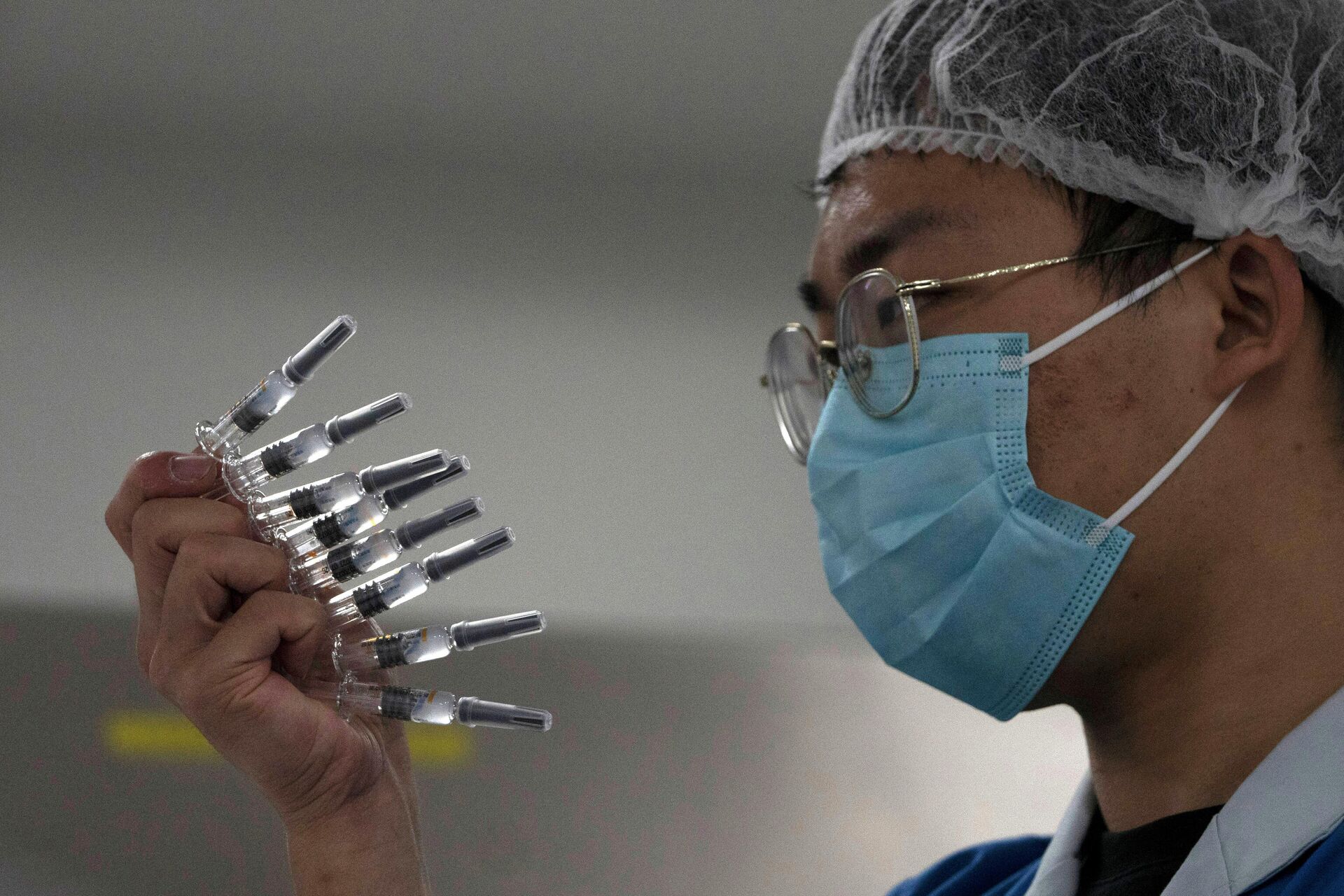 Сотрудник проверяет шприцы с вакциной против вируса SARS CoV-2 на заводе в Пекине - РИА Новости, 1920, 29.06.2021