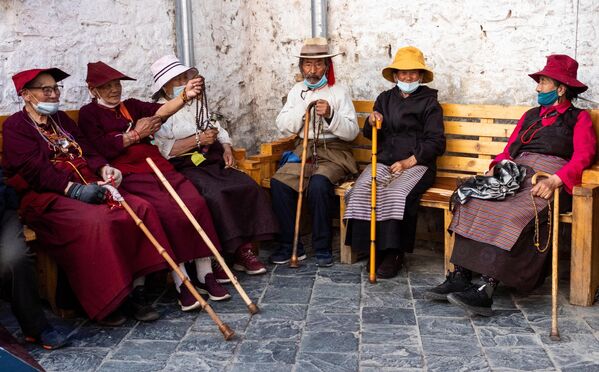 Местные жители на пешеходной улице Баркхор в центре города Лхаса в Тибете