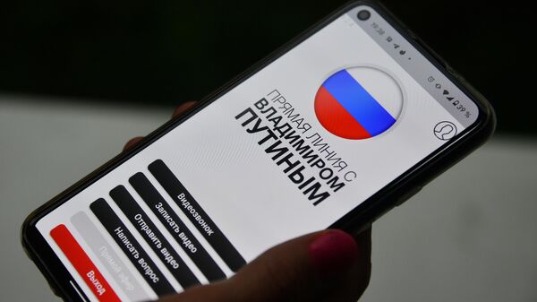 Девушка держит в руке смартфон с открытым мобильным приложением Москва-Путину, где можно задать вопрос к прямой линии с президентом РФ  Владимиром Путиным